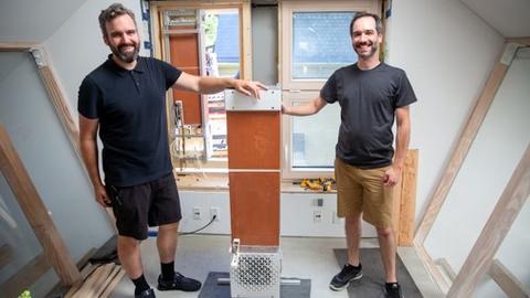 Jonathan Grinham and Jack Alvarenga, two of the team leads, with an evaporative cooling unit as it was installed at HouseZero. Credit: Wyss Institute at Harvard University